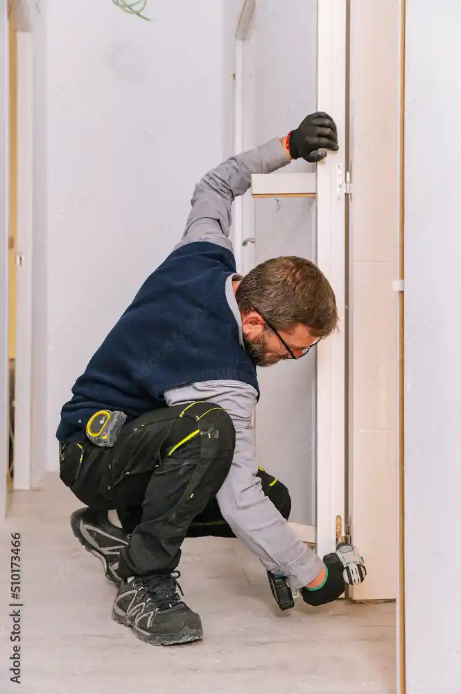 A technician performing expert commercial door repair on a shop.